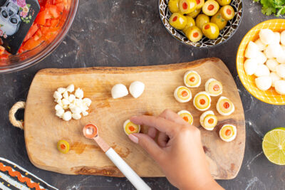 placing a sliced pimento olive in the center of mozzarella balls