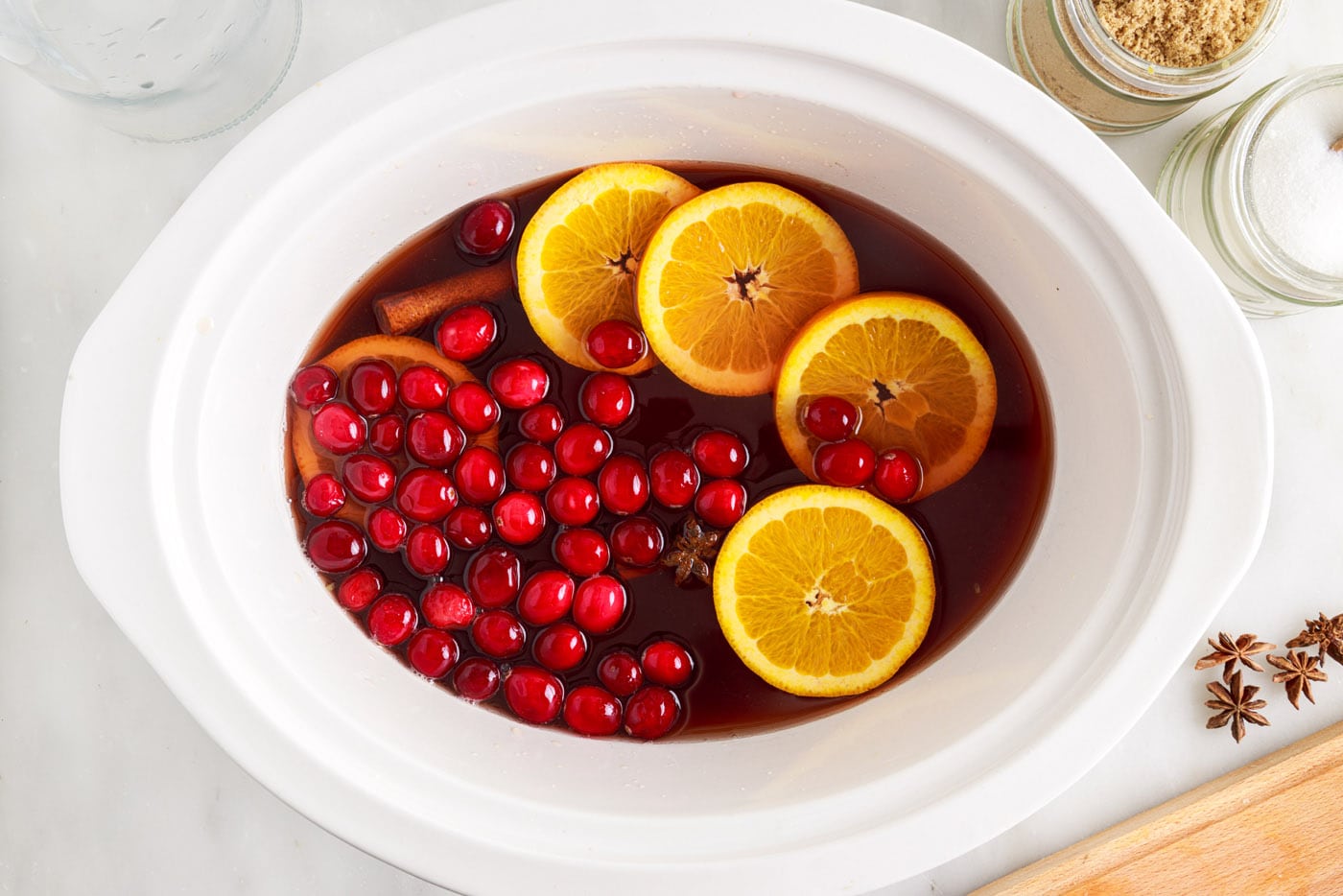 orange slices and cranberries in hot cranberry punch in the slow cooker