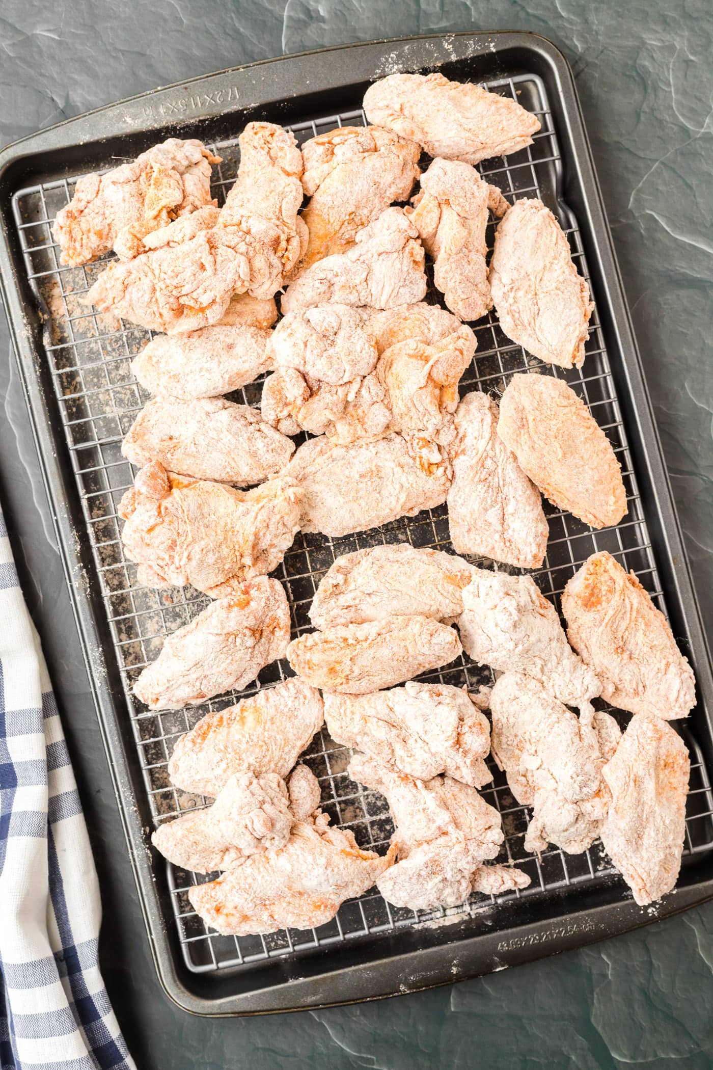 flour dredged chicken wings on a baking sheet