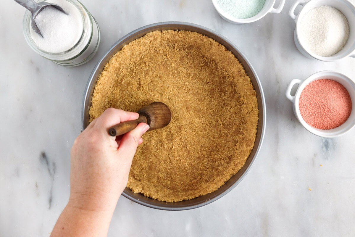pressing graham cracker crumbs into springform pan