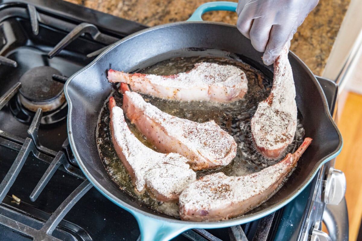 placing lamb chop in a skillet