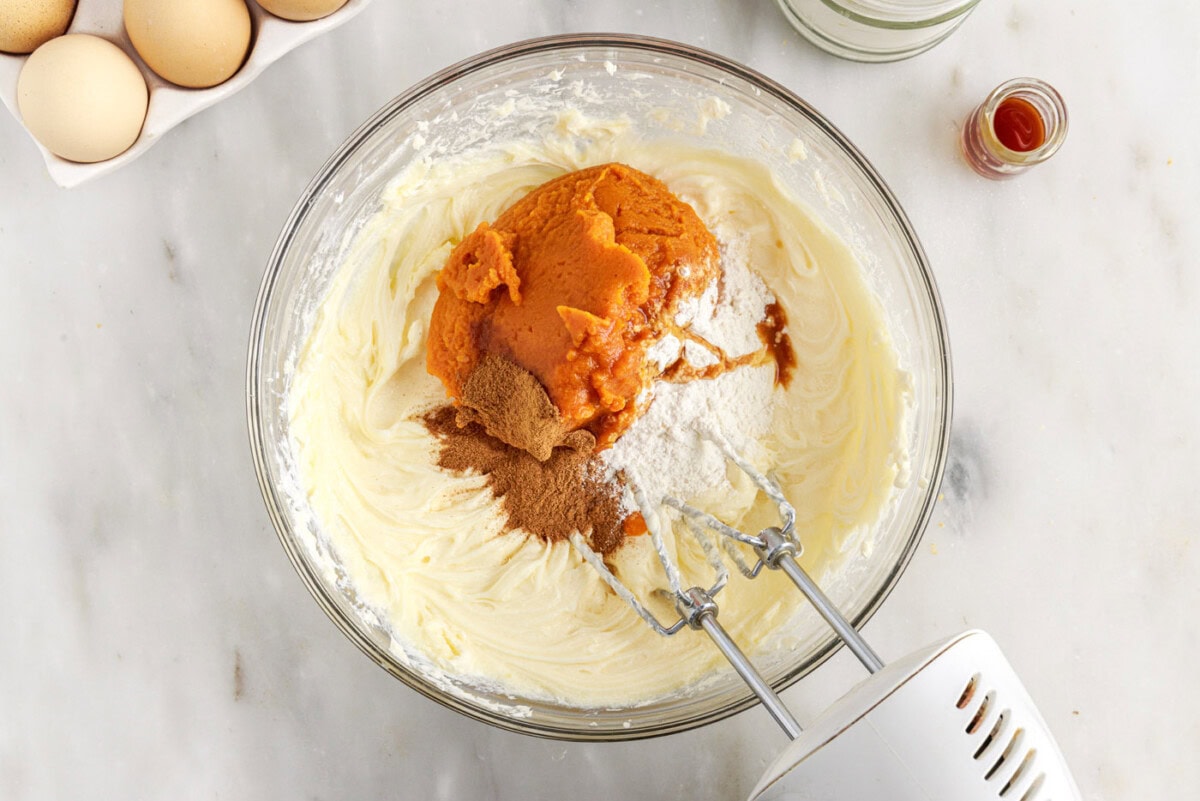pumpkin cheesecake filling in a bowl with a mixer
