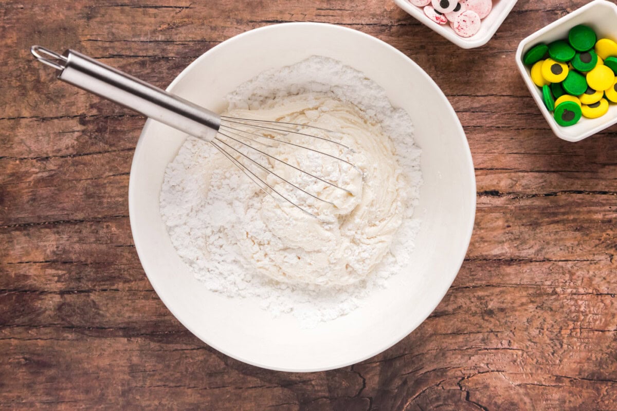 whisking powdered sugar with vanilla frosting
