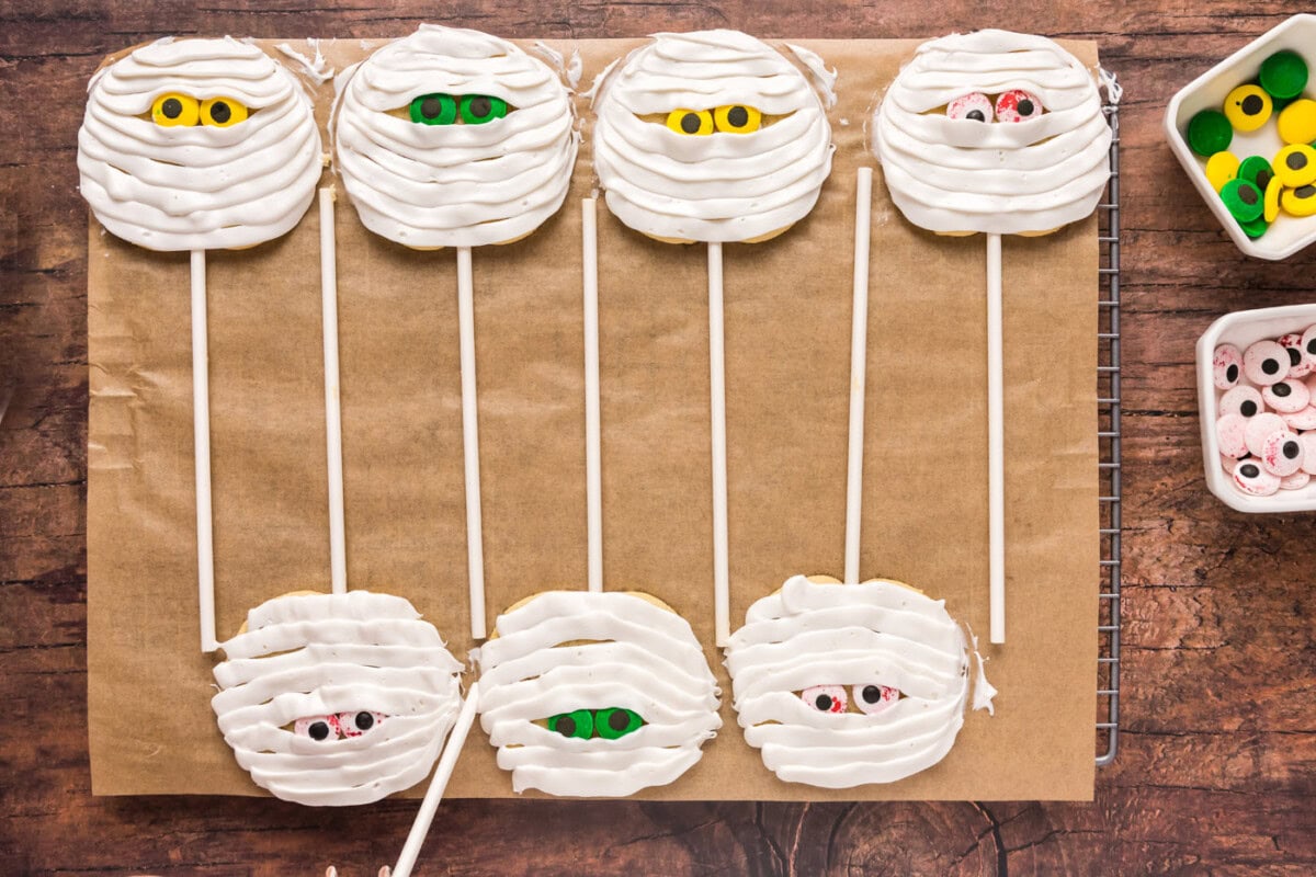 mummy cookie pops on a baking sheet