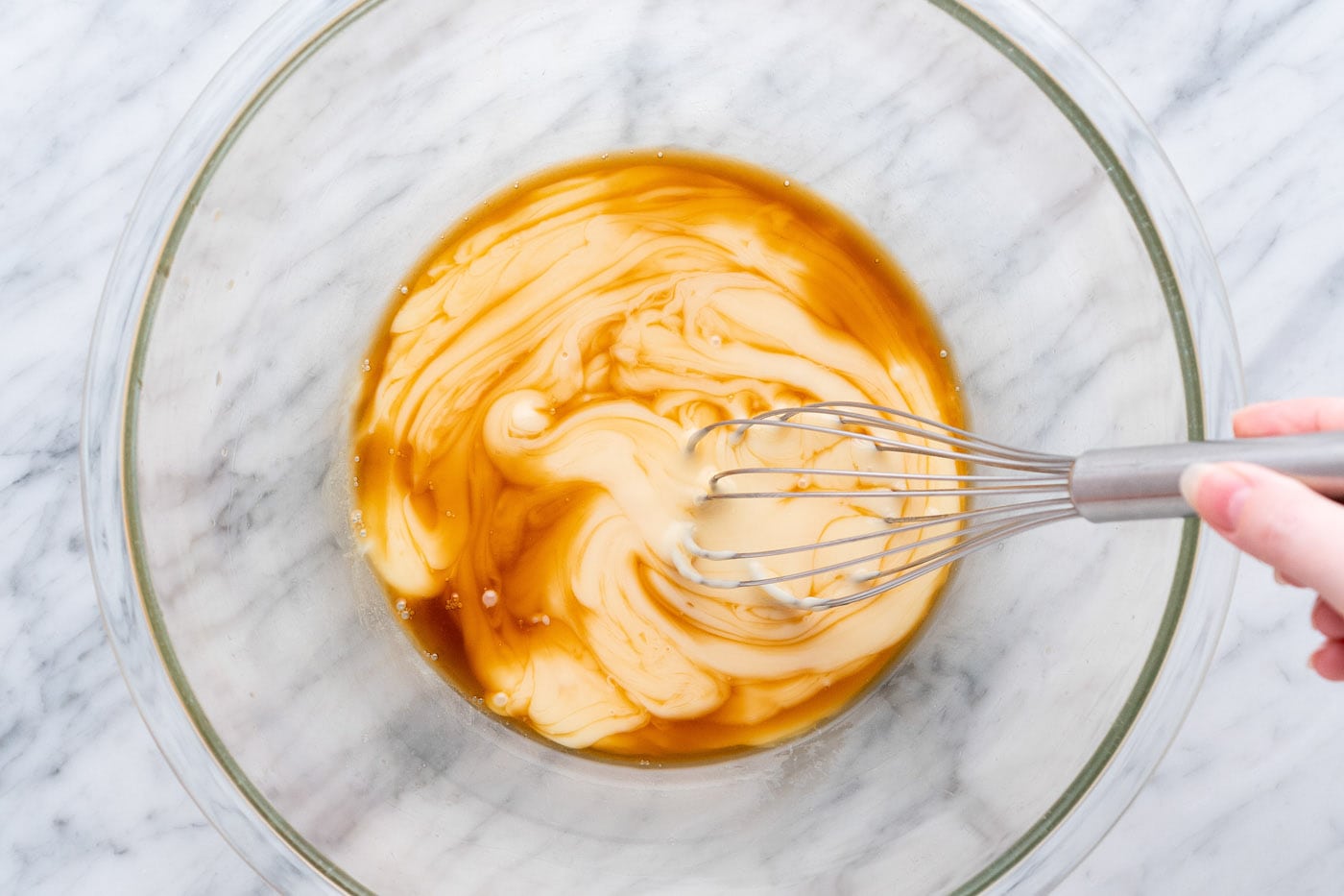 whisking vanilla and sweetened condensed milk together in a bowl