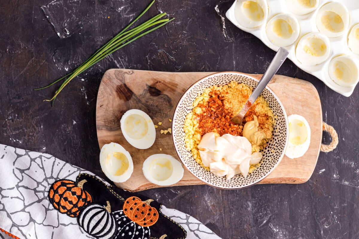 mashing deviled egg ingredients in a bowl