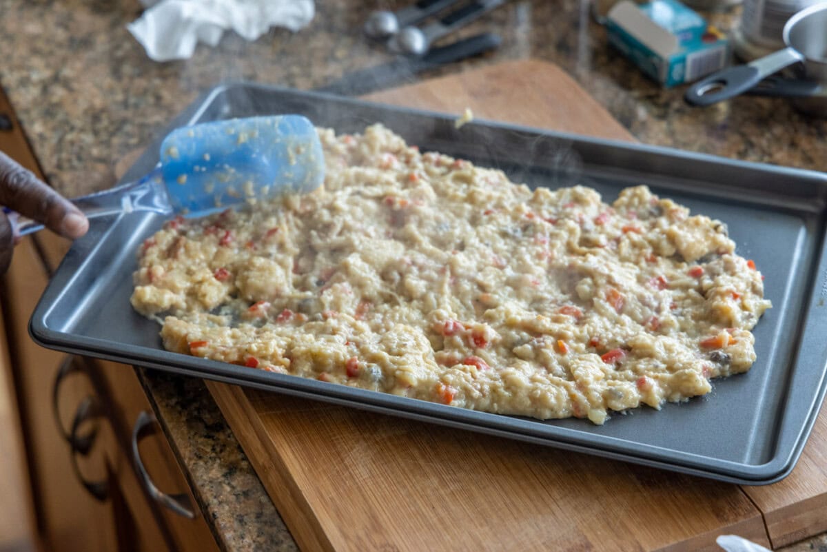 spreading stuffed chicken breast on a baking sheet