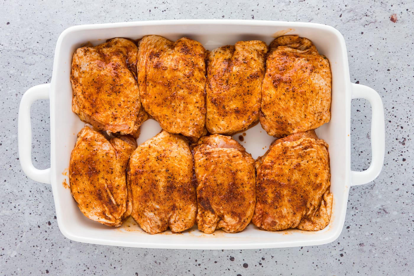 seasoned chicken thighs in a baking dish