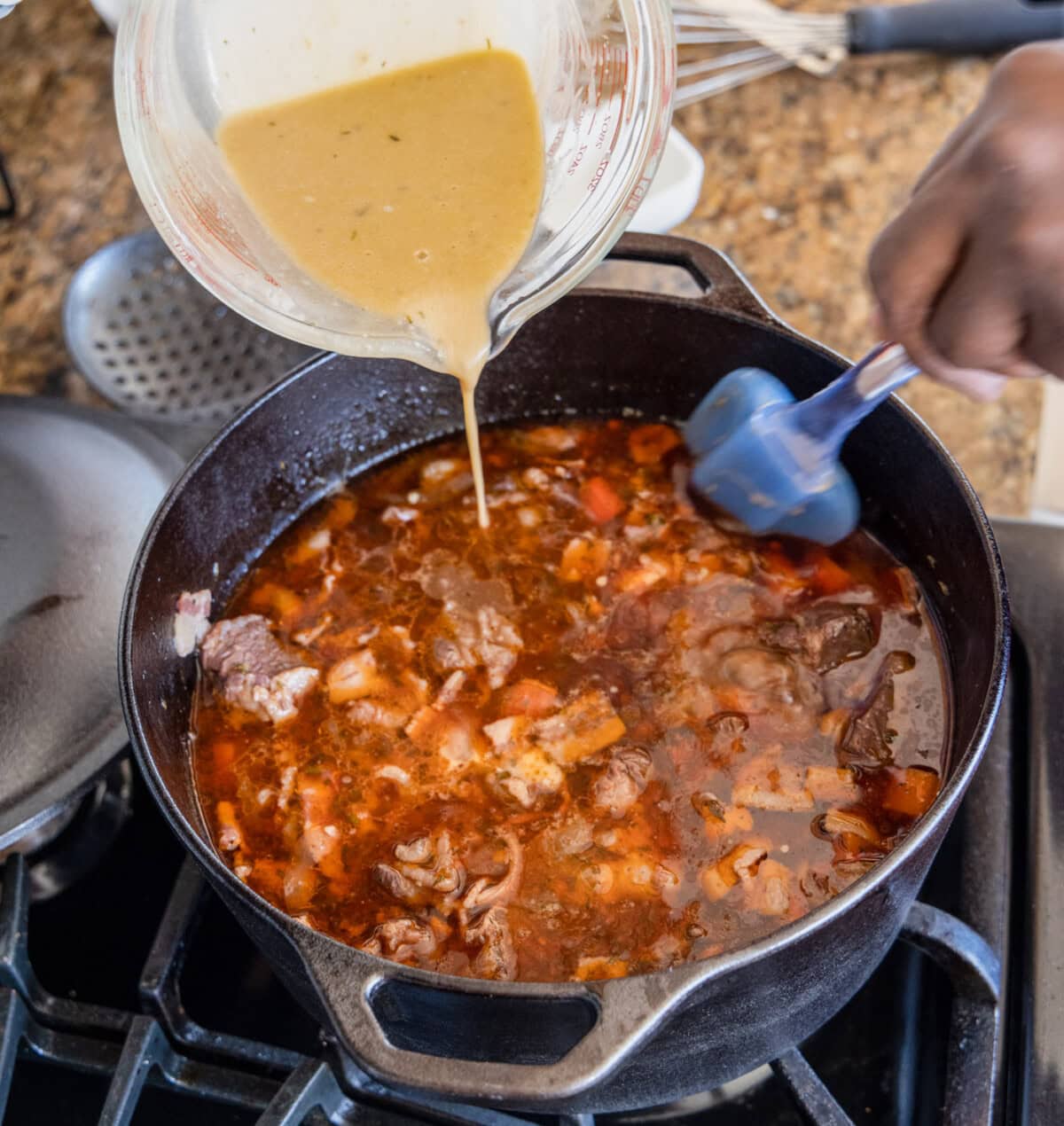 pouring flour and pan juice mixture into beef bourguignon