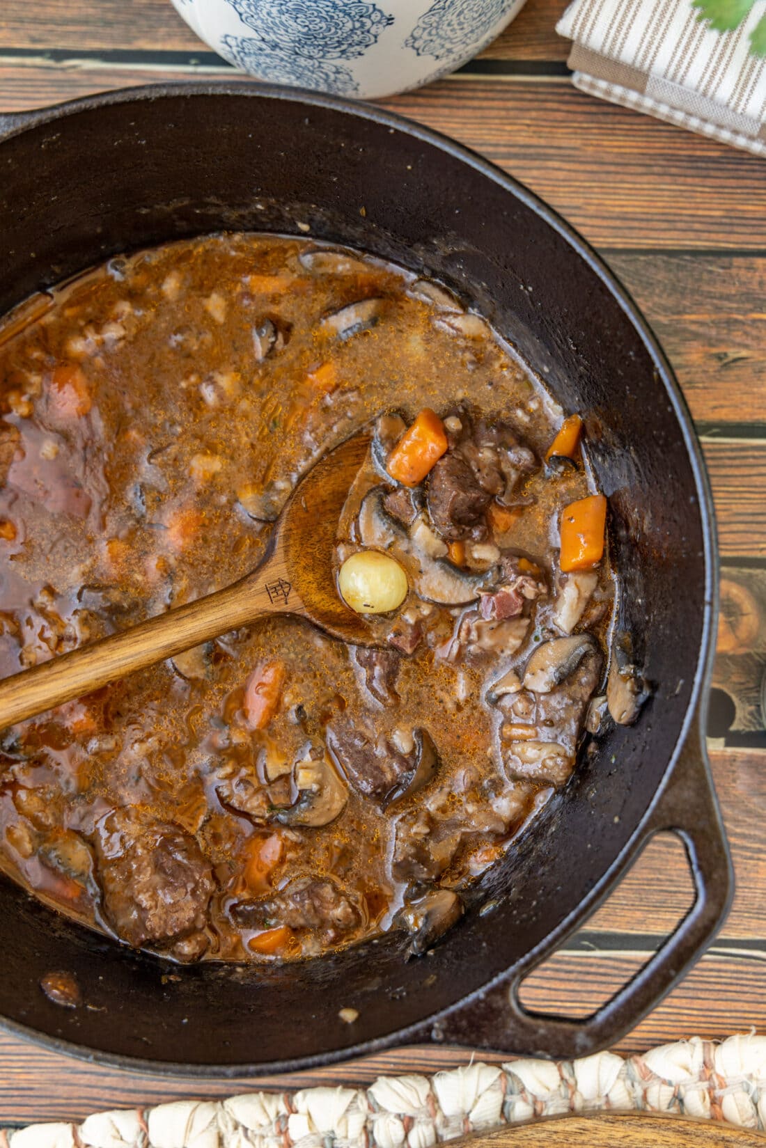 Beef Bourguignon in a pot with wooden spoon