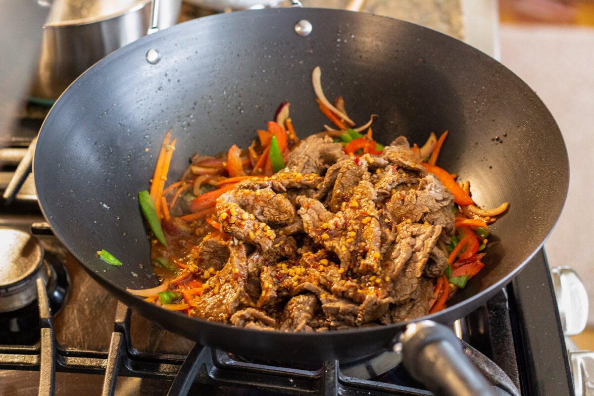 beef lo mein with sauce in a wok