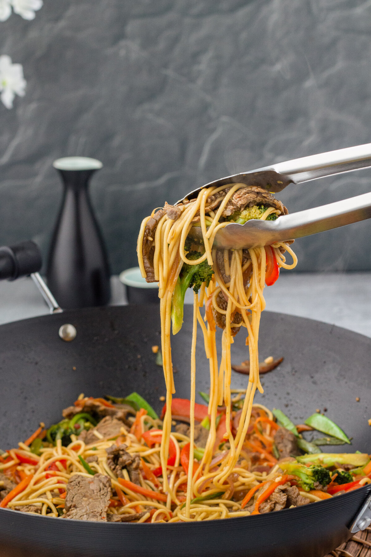tongs lifting Beef Lo Mein