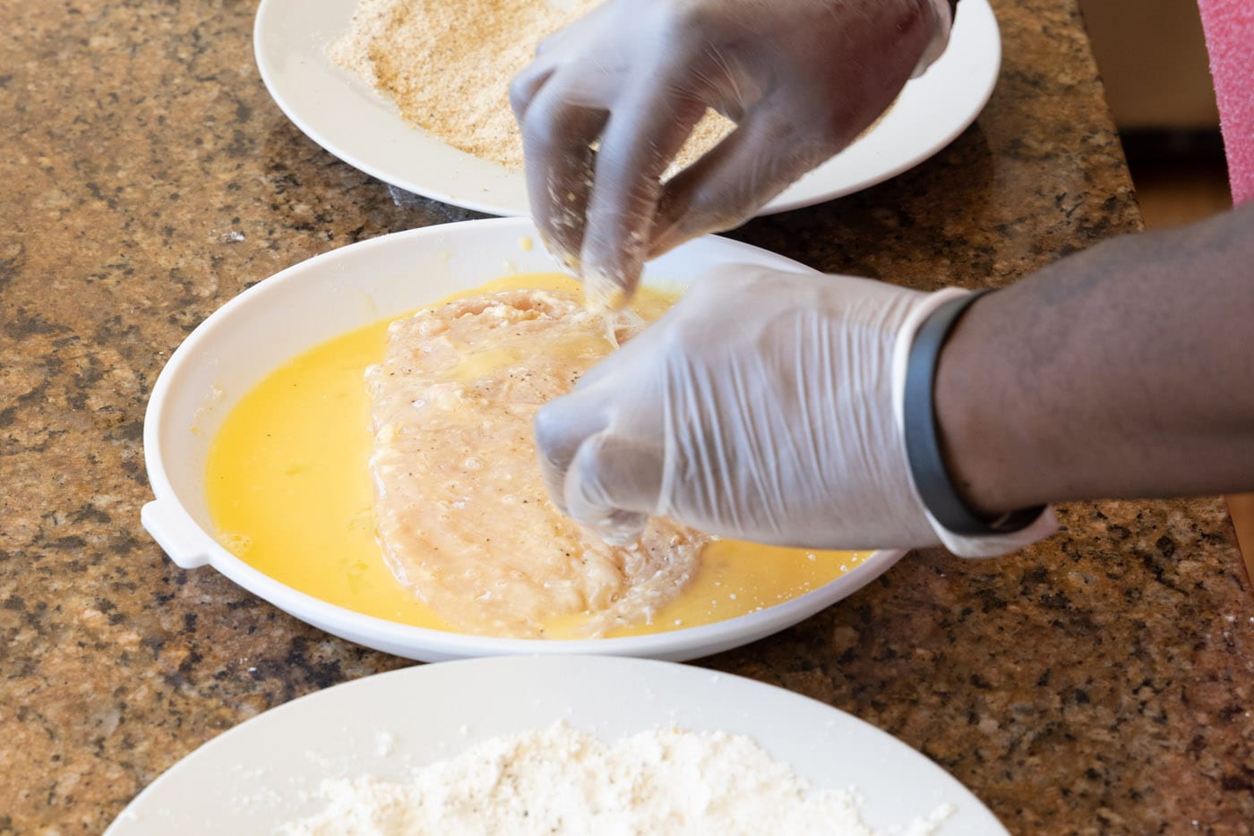dredging flour chicken cutlet in egg