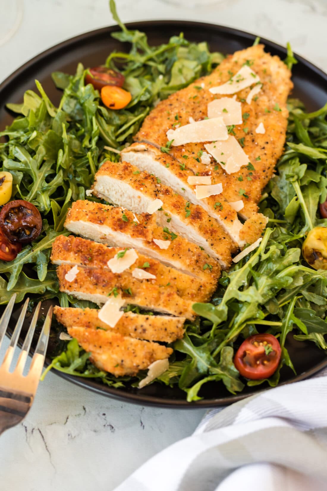 Chicken Milanese on a plate with greens