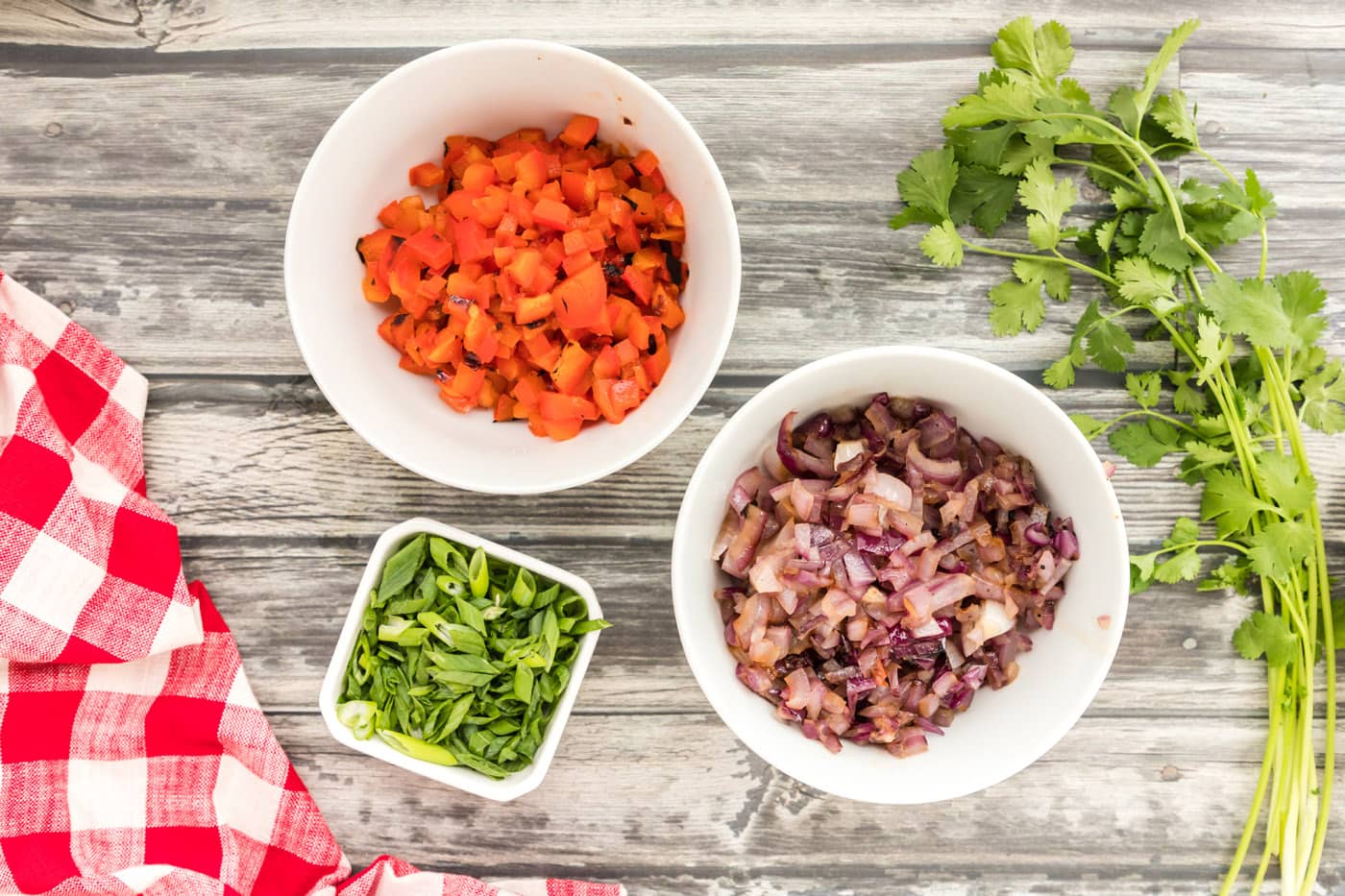 red bell pepper, red onion, and green onion diced in bowls