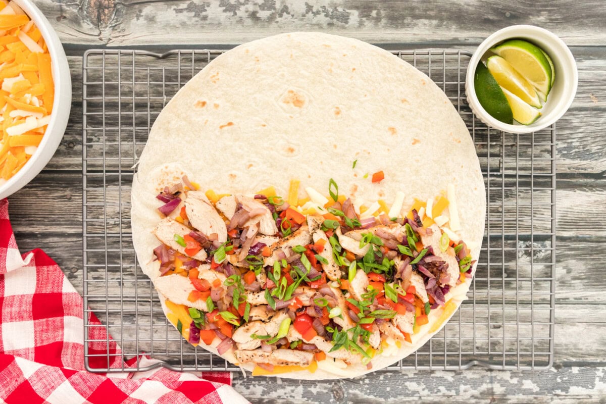 chicken, bell pepper, onions and cheese on a tortilla