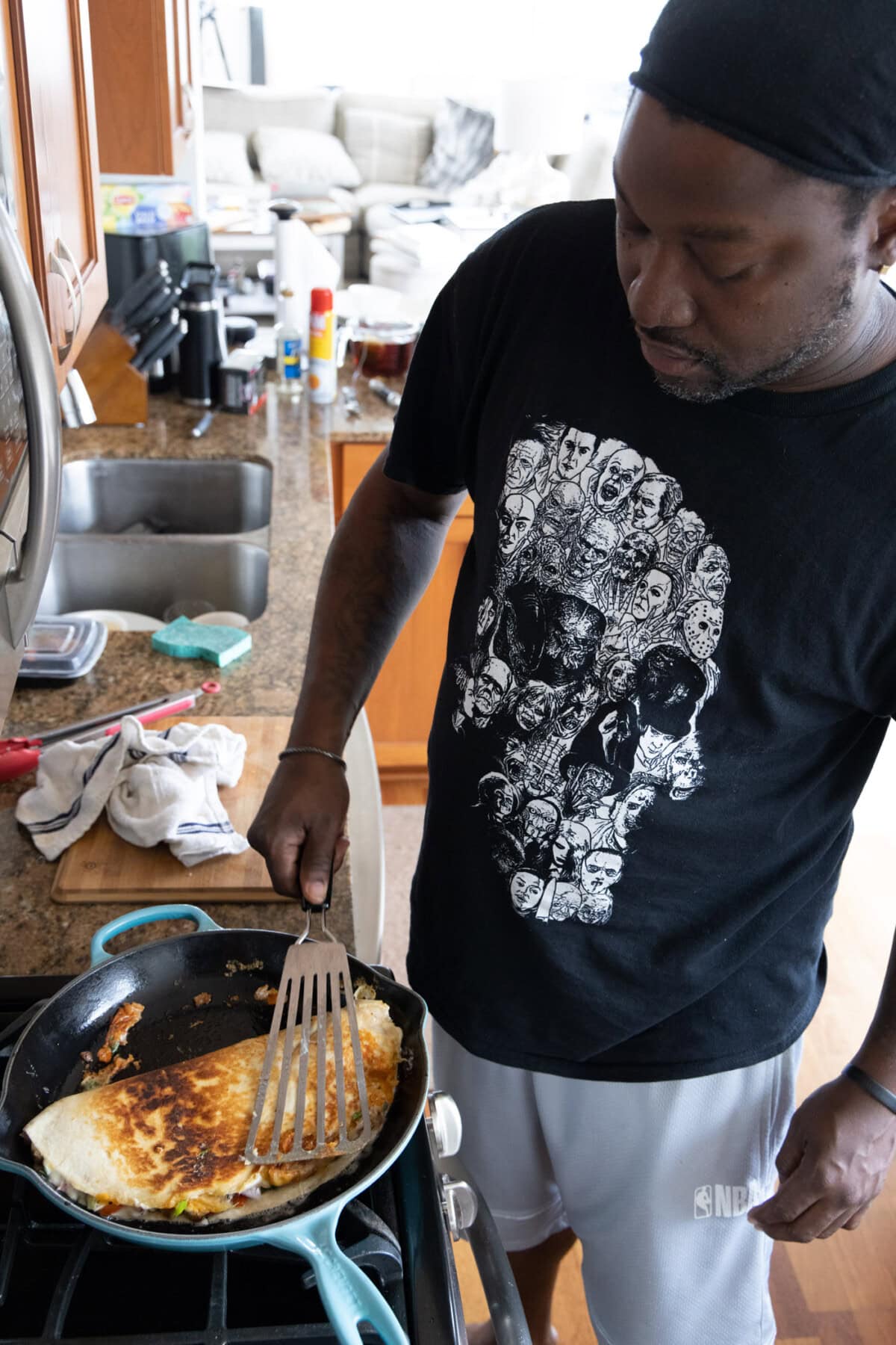 man flipping chicken quesadilla in a skillet