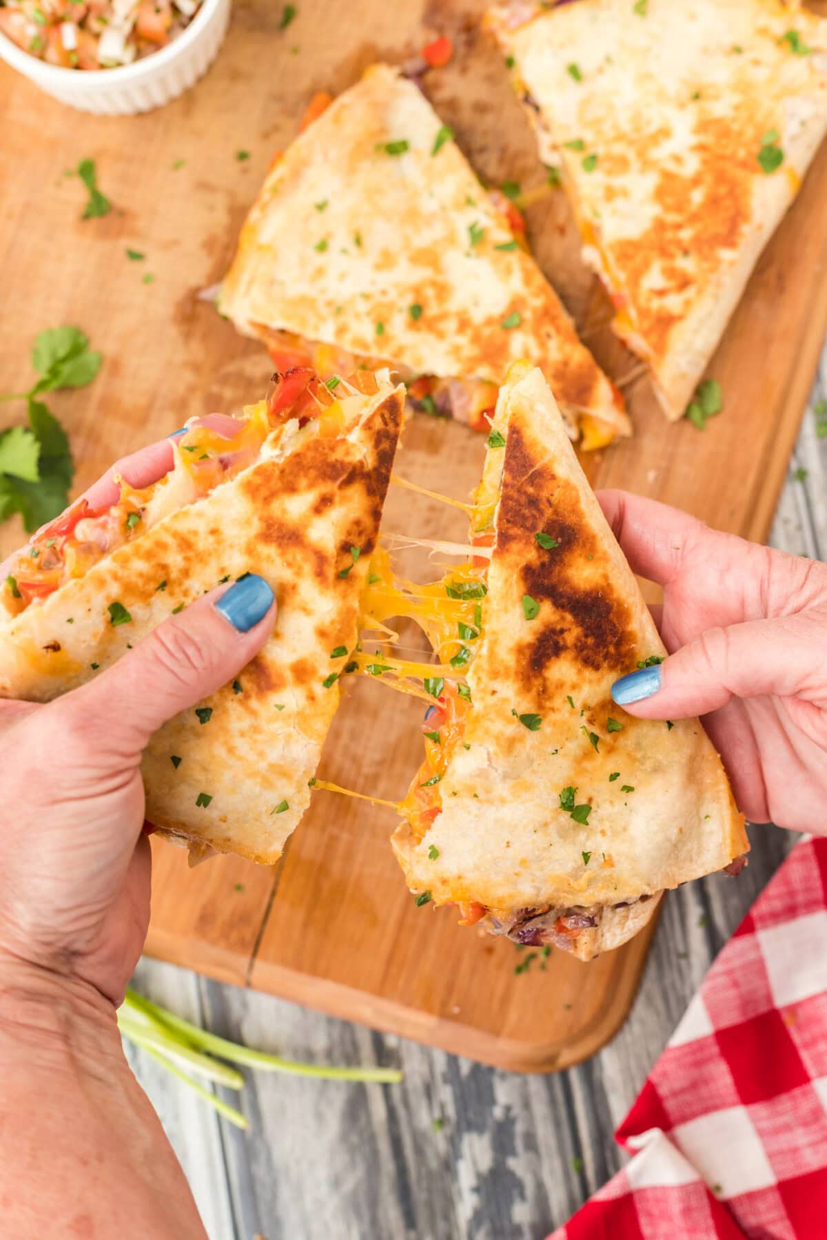 pulling a cheesy Chicken Quesadilla apart