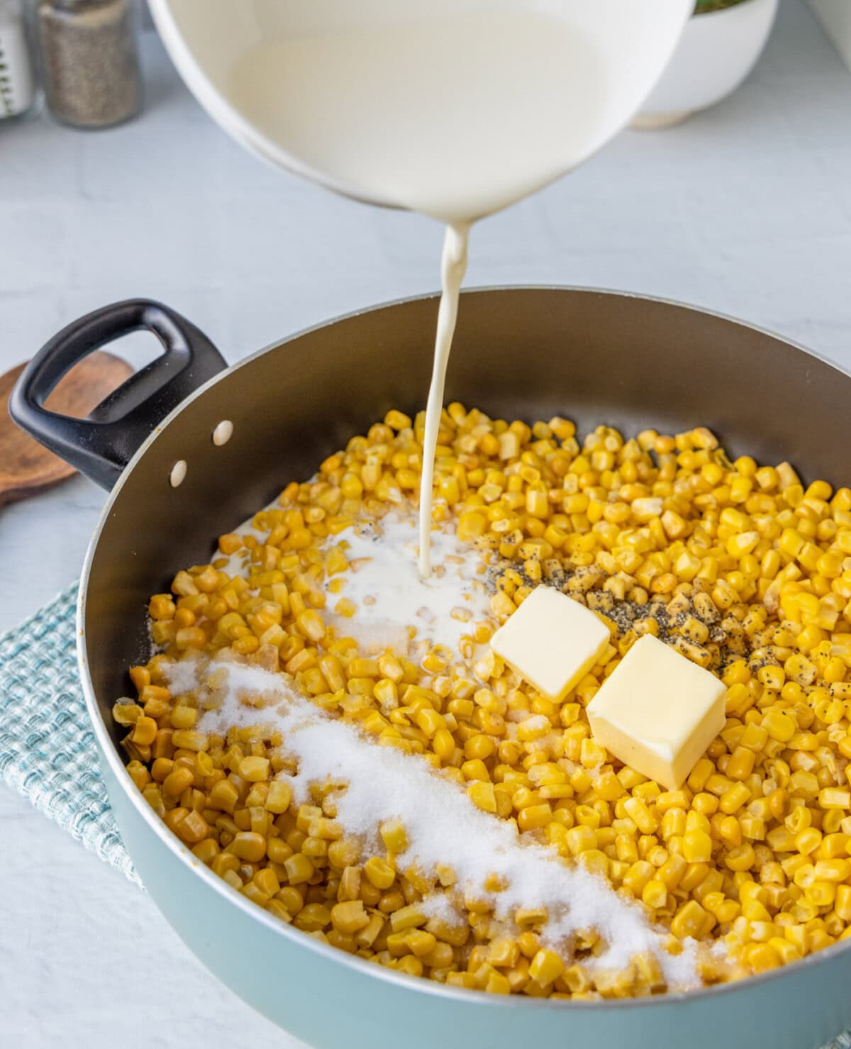 pouring heavy cream into saucepan