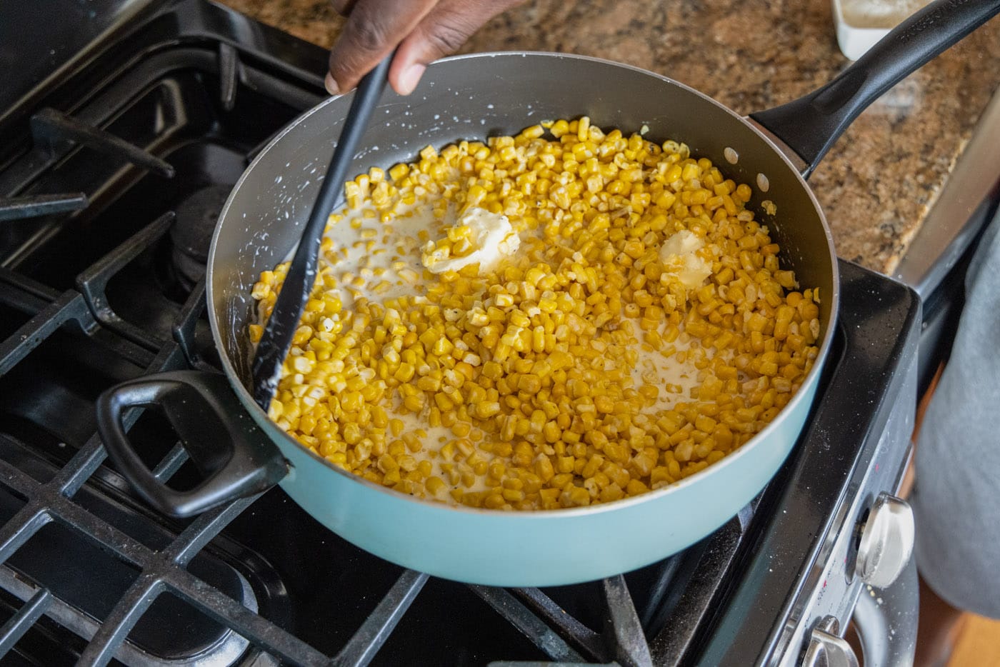 mixing creamed corn in a skillet