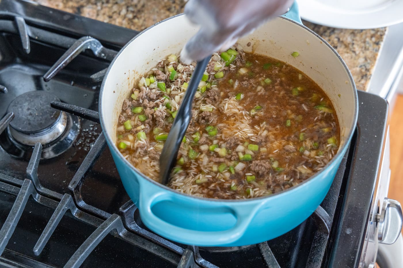 mixing dirty rice in a dutch oven
