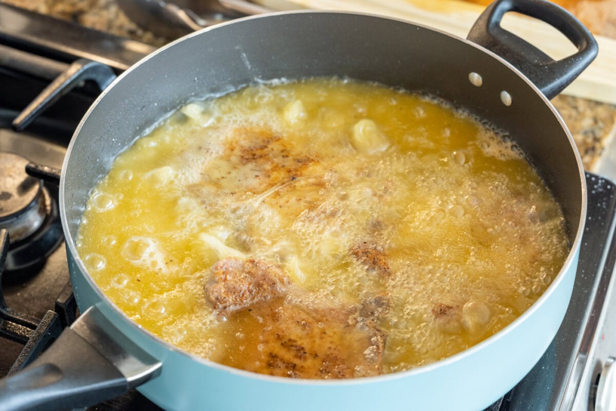 pork chops frying in a skillet