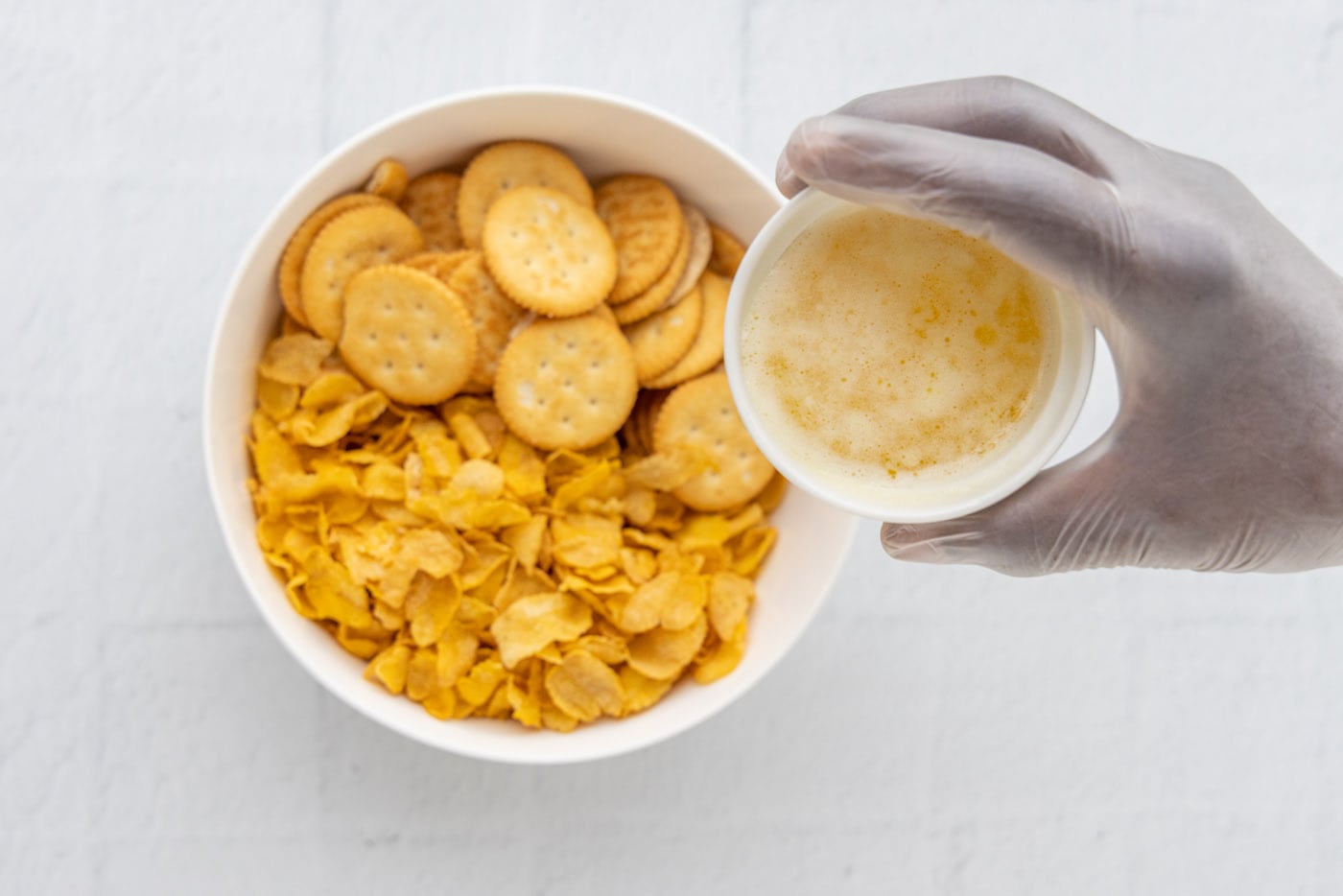 ritz crackers and cornflakes in a bowl with melted butter