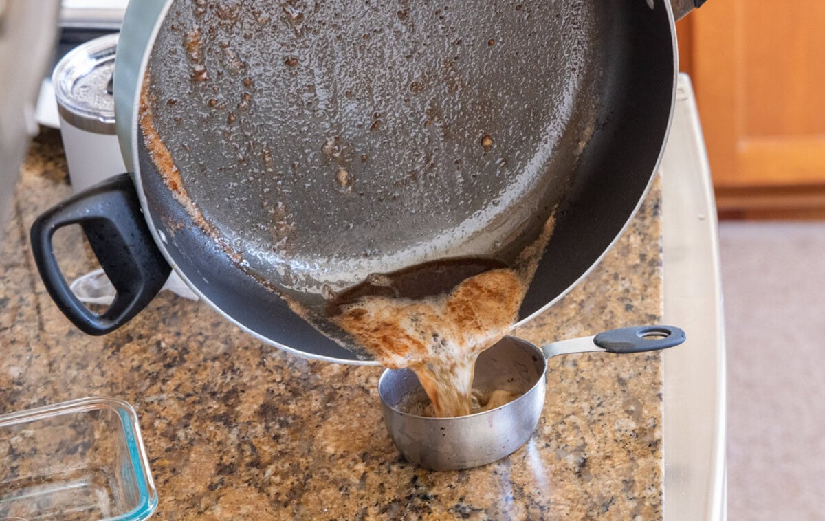 draining oil and butter mixture from chicken