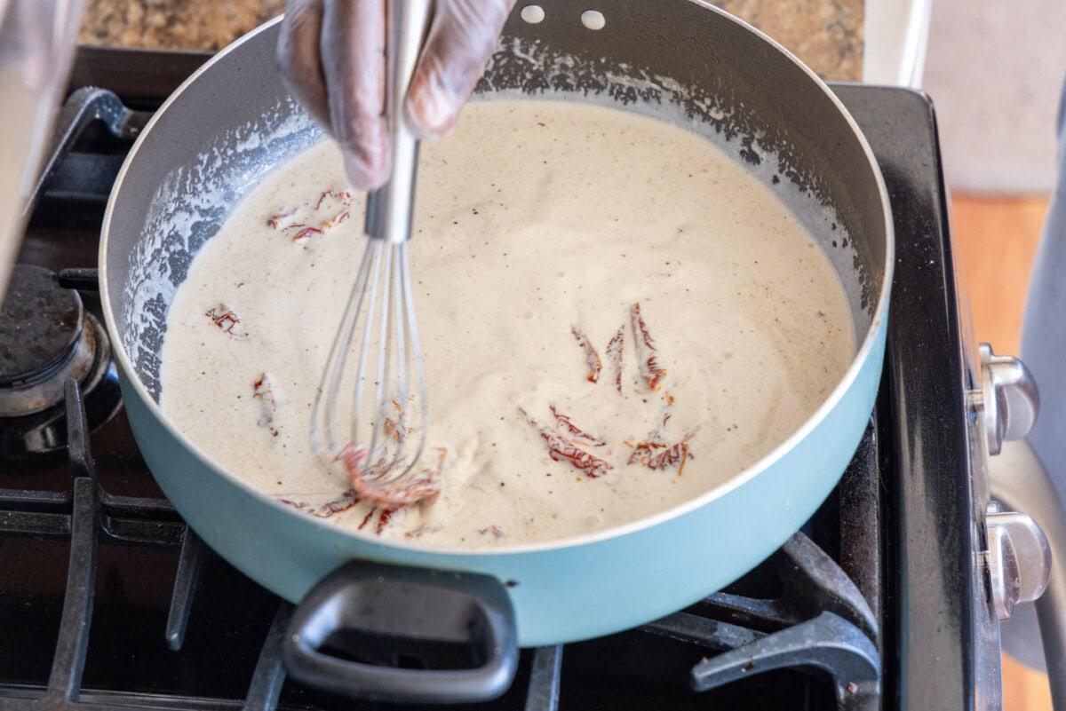 whisking heavy cream mixture in a skillet