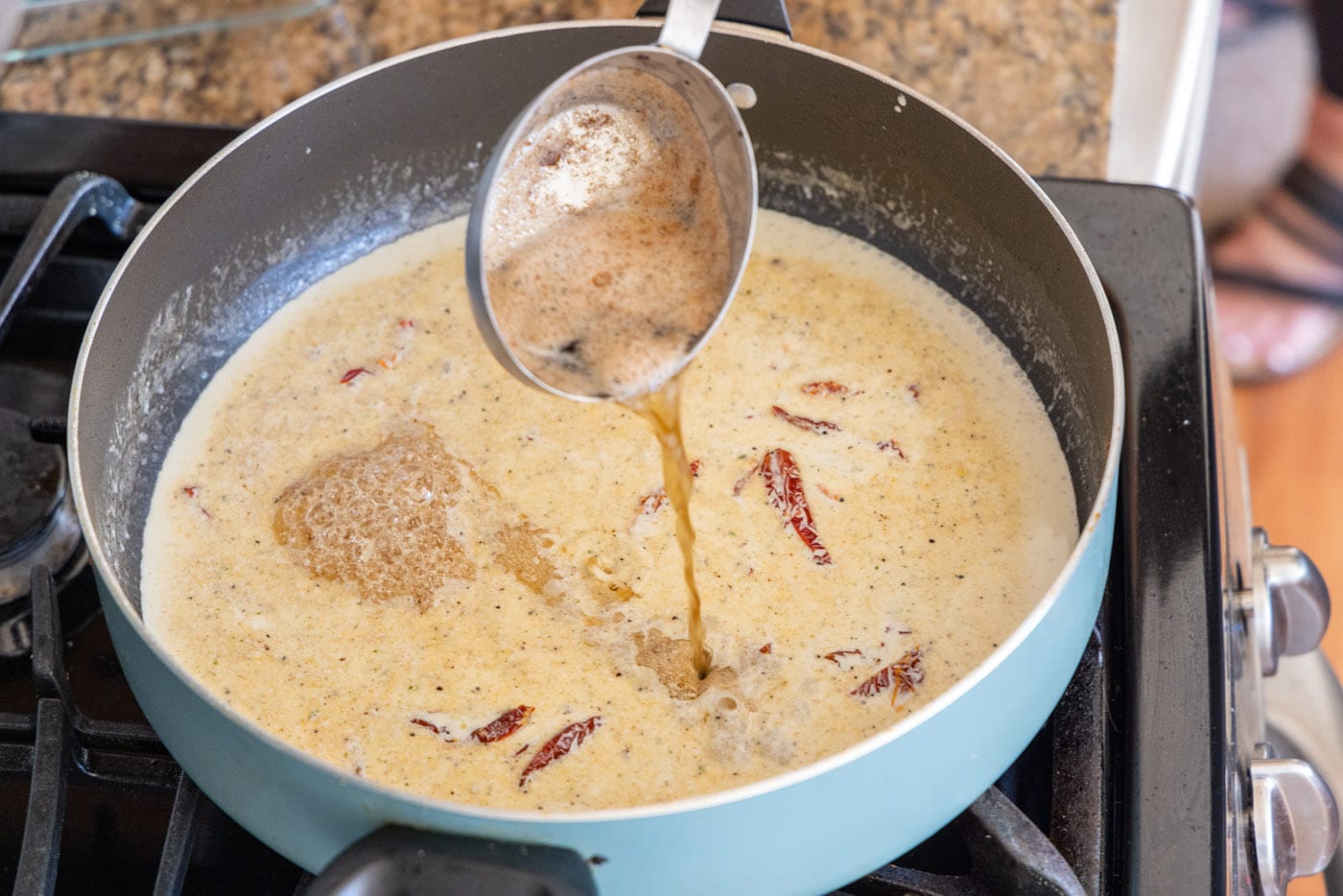 adding reserved butter and oil mixture to heavy cream in a skillet