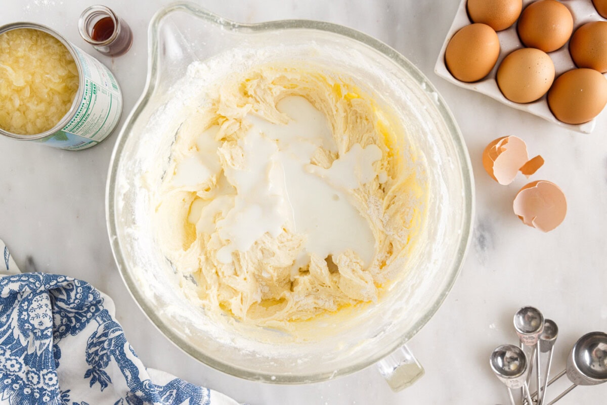 buttermilk added to pound cake ingredients in a bowl