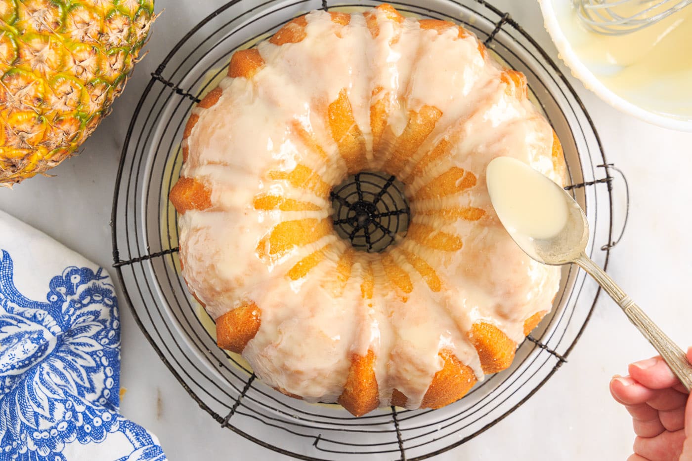 spooning glaze over pineapple pound cake