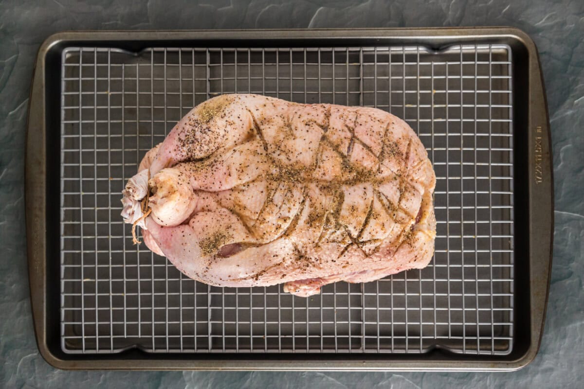 scored whole duck on a baking sheet