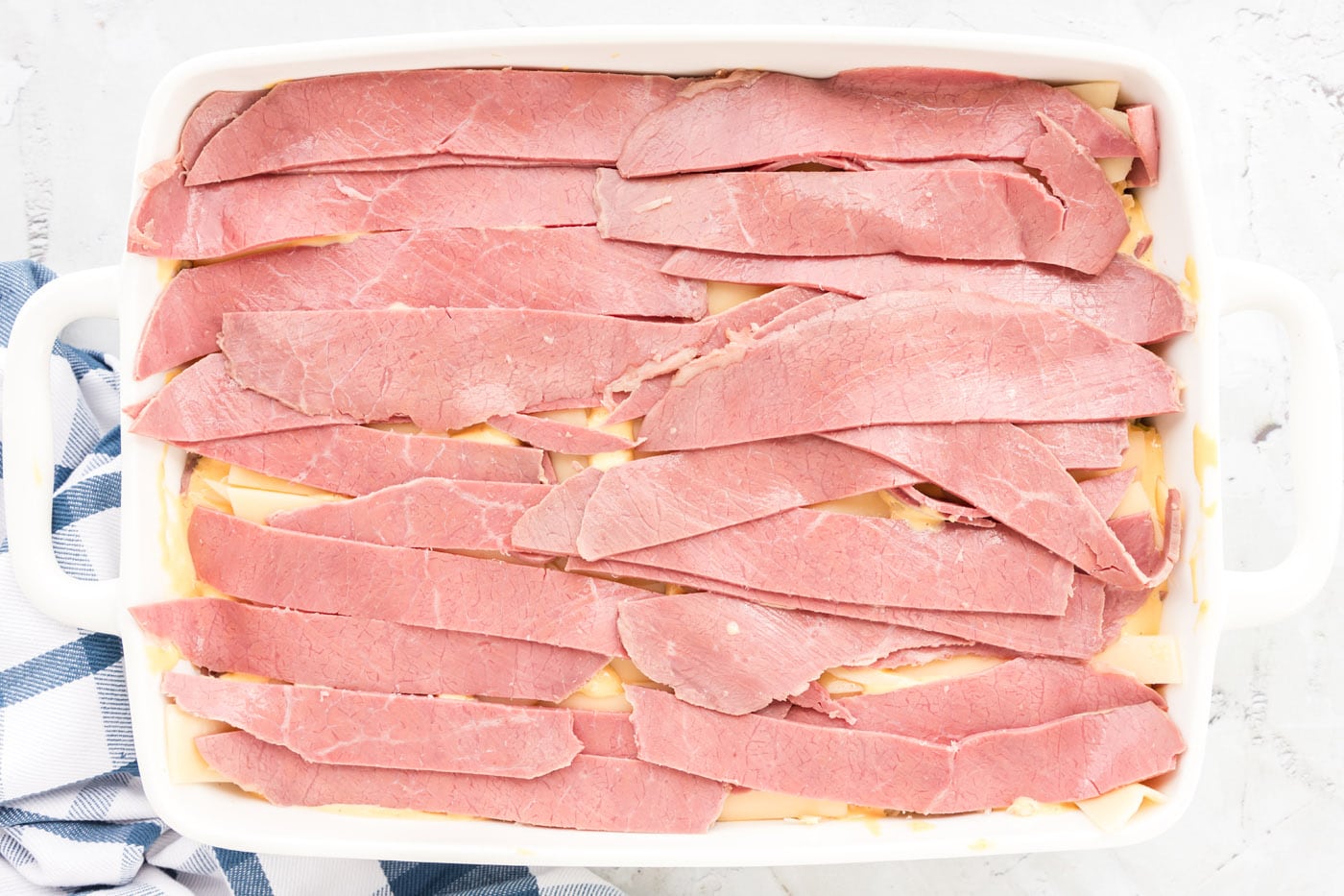 layer of corned beef strips in a baking dish