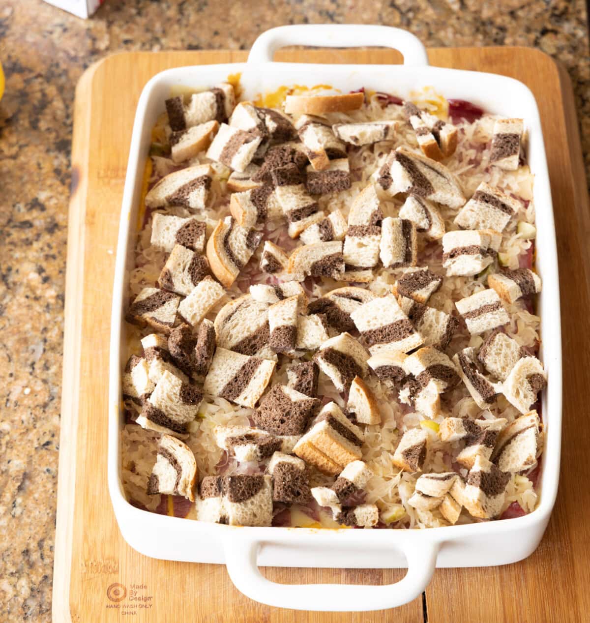 adding bread cubes to the top of reuben casserole