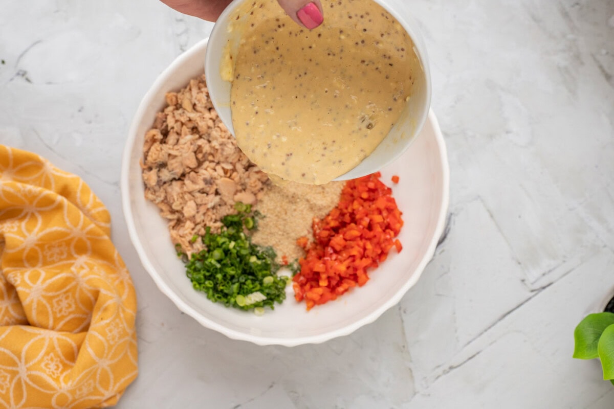 pouring sauce mixture over salmon patty mixture