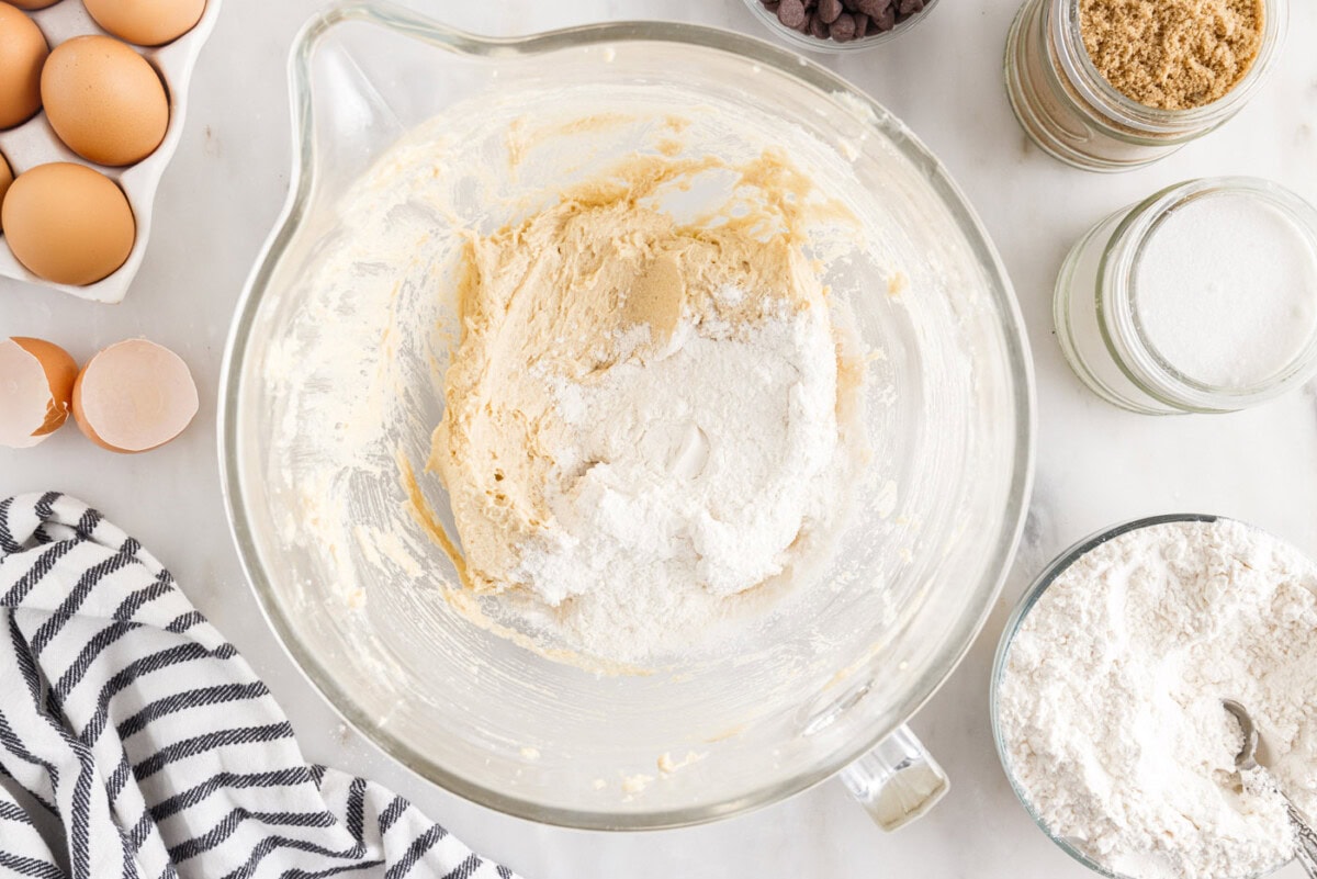 adding flour mixture to butter mixture in a bowl