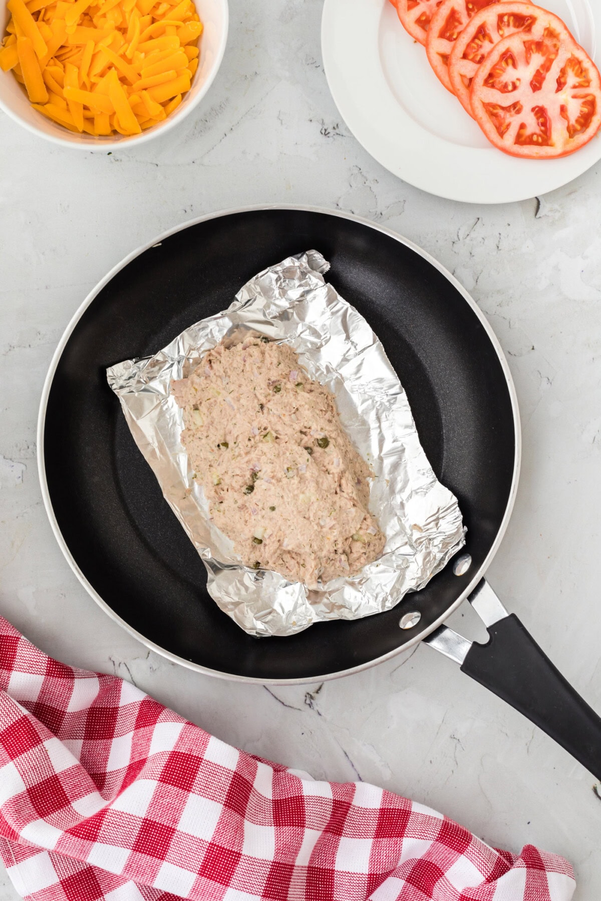 tuna salad in an aluminum foil bowl in a skillet
