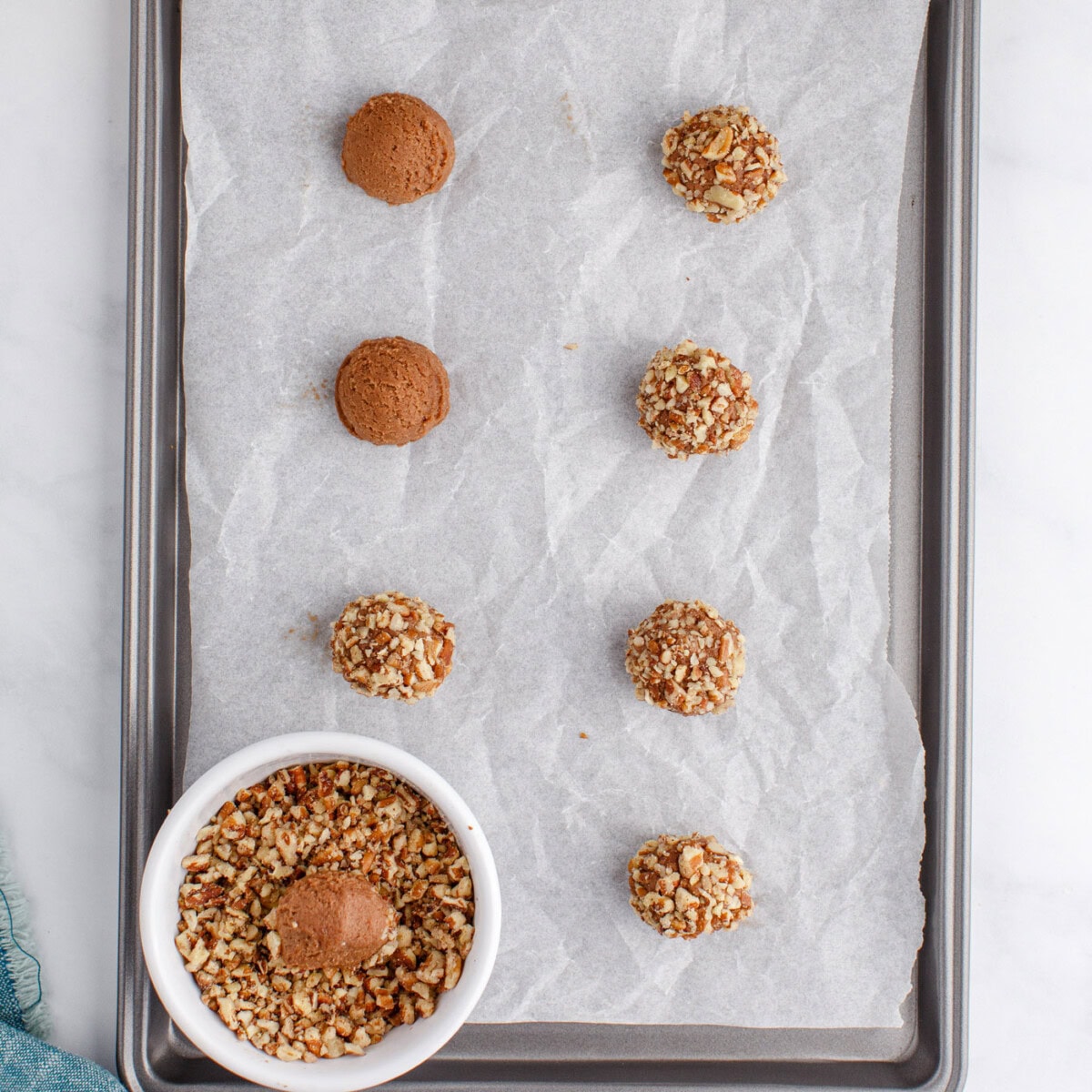 rolling turtle thumbprint cookies in pecans