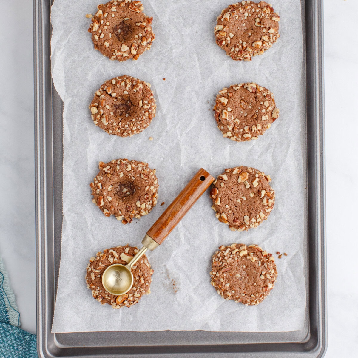 measuring spoon creating indents in thumbprint cookies