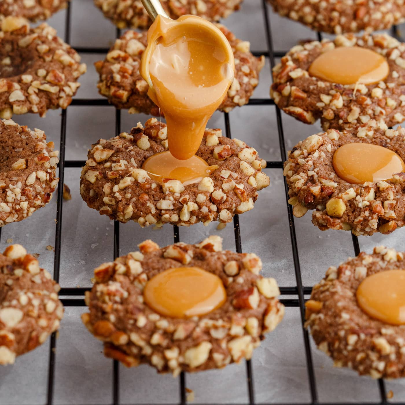 pouring caramel into turtle thumbprint cookies