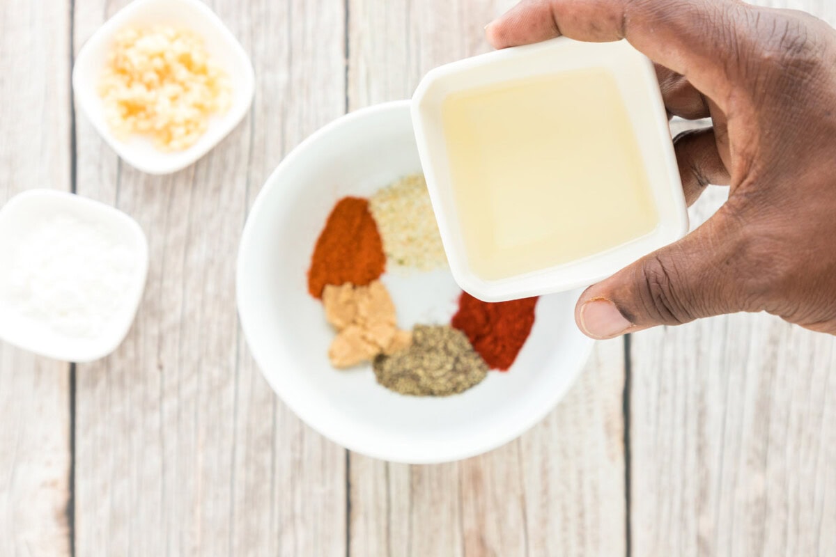 olive oil over bowl of seasonings