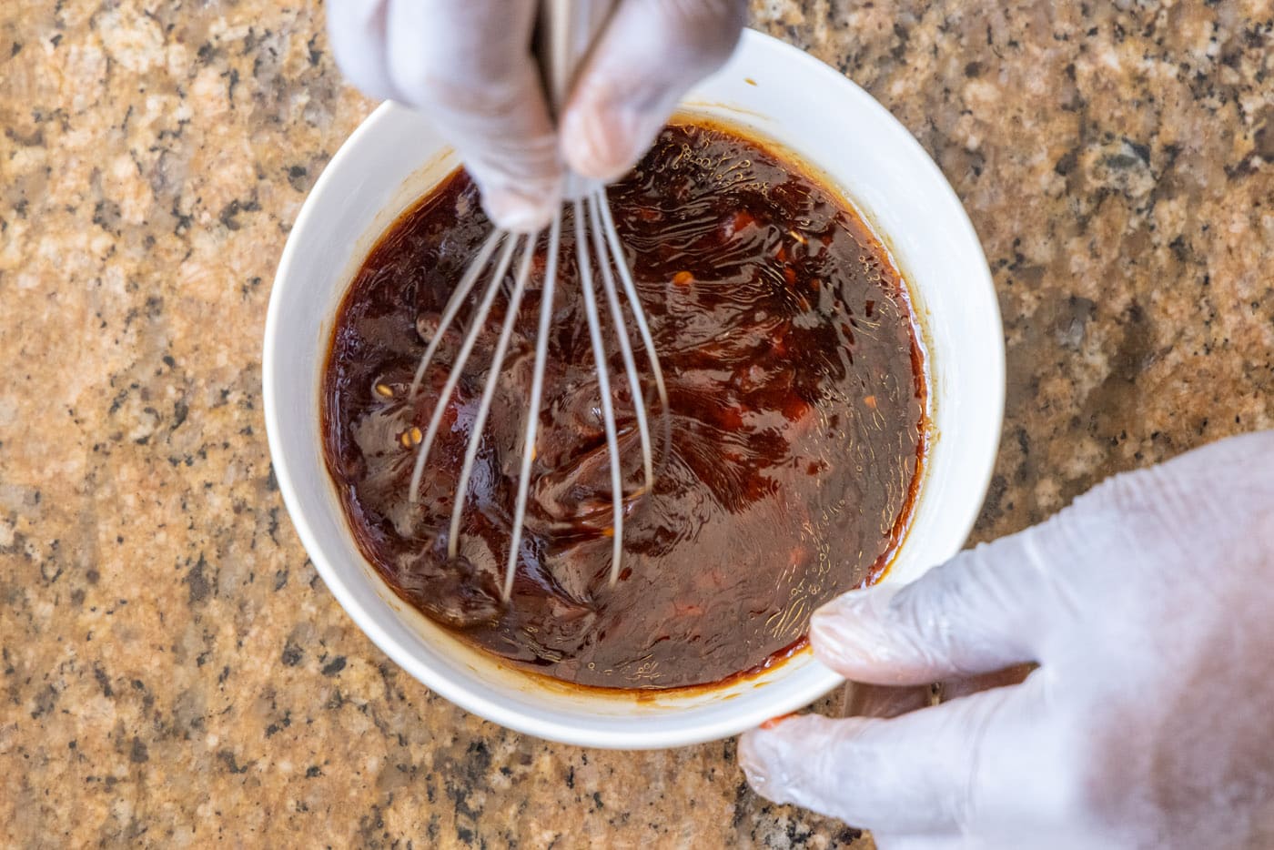whisking kung pao sauce in a bowl