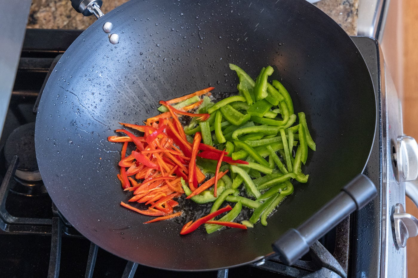 red jalapenos and green peppers in a wok