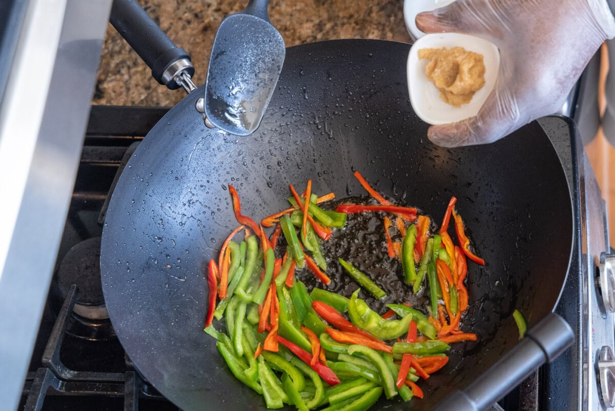 adding ginger to pan of stir fry veggies