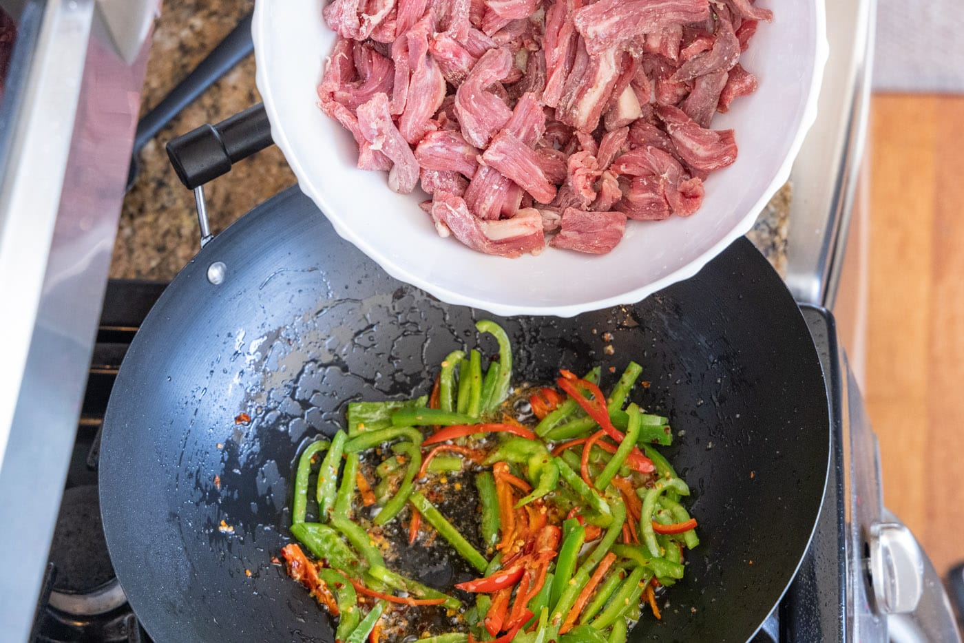 adding flank steak to stir fry veggies