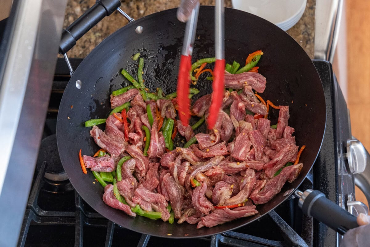 mixing beef and veggies in wok