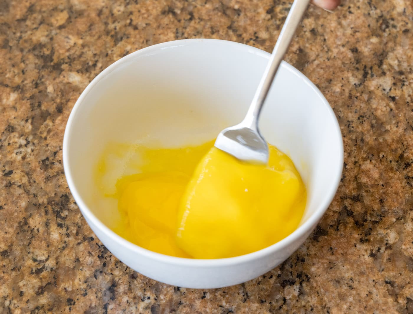 whisking eggs in a bowl with a fork