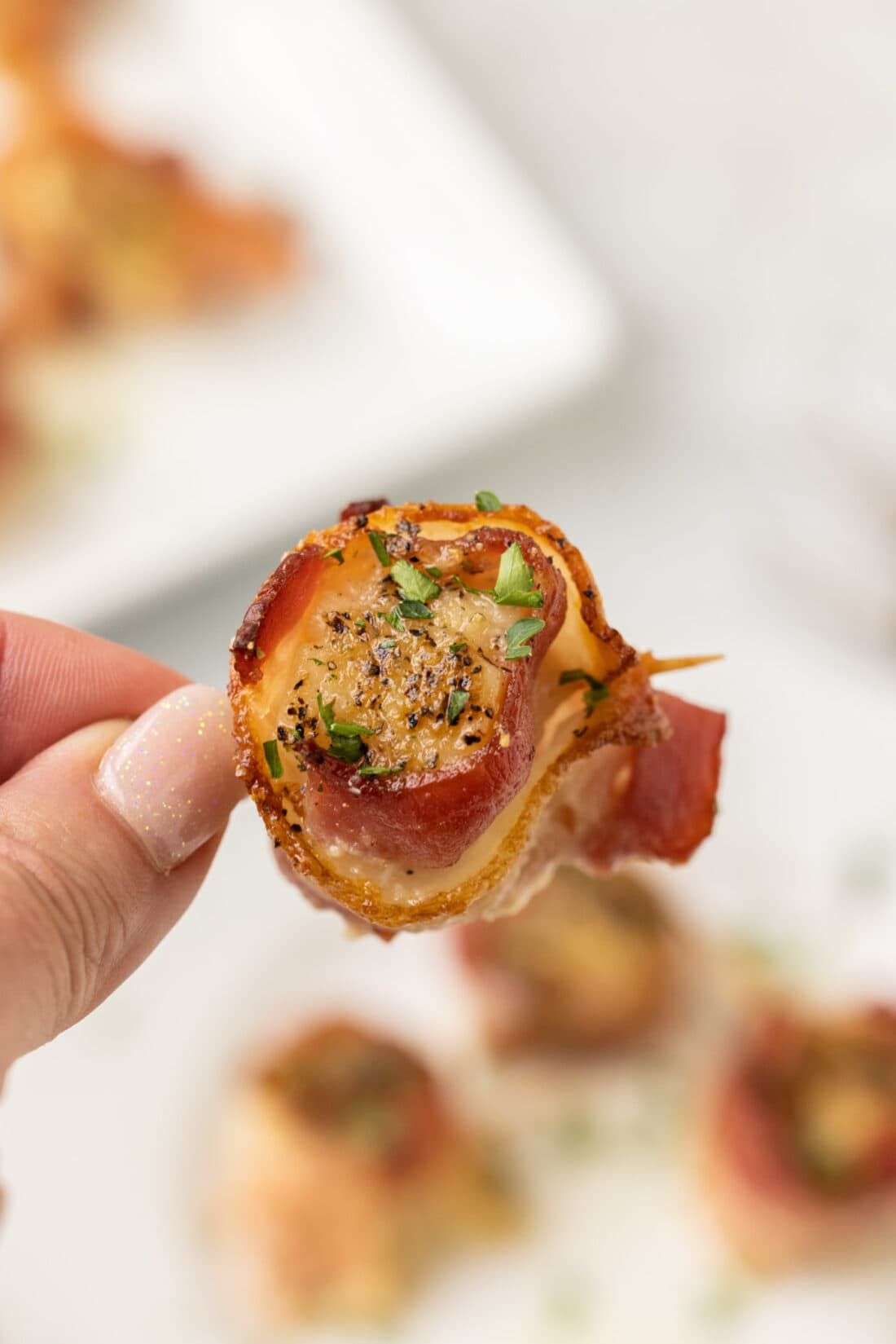 hand holding a Bacon Wrapped Scallop