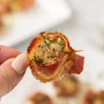 hand holding a Bacon Wrapped Scallop